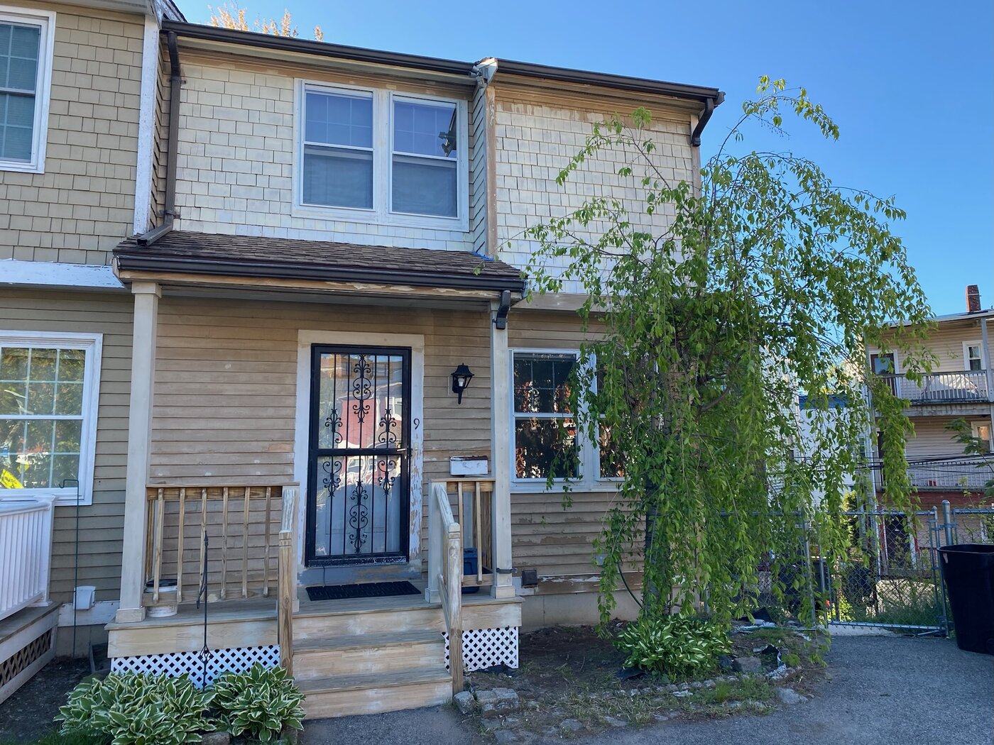 Same home before painting, with faded and peeling tan siding