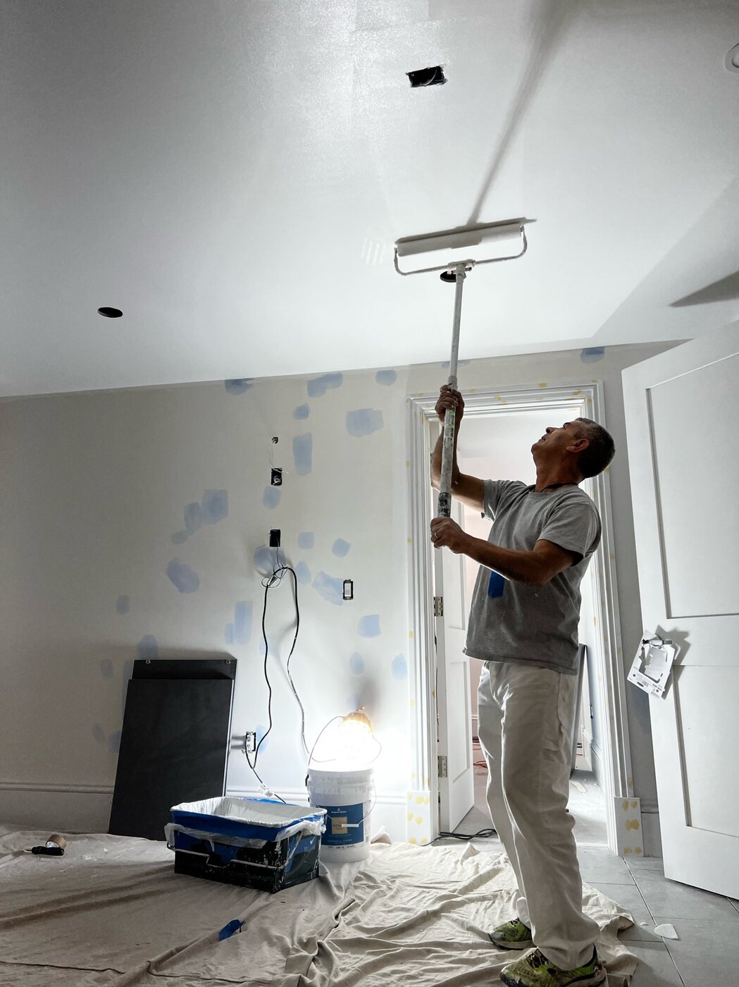 Painter rolling a ceiling white